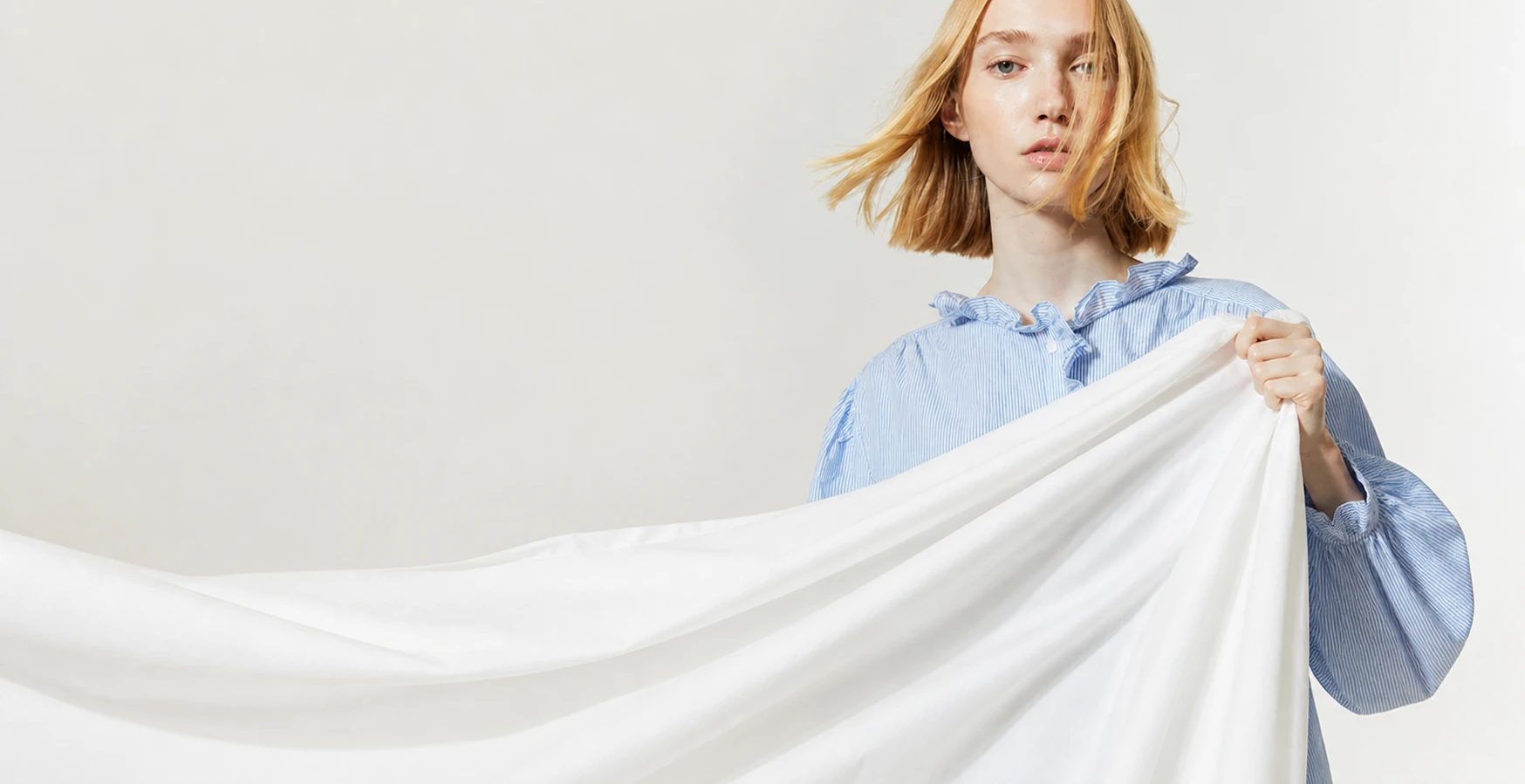 girl holding white bedsheet in hand